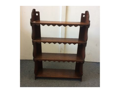 An oak wall hanging book shelf, with four graduated shelves with shaped sides, width 62 cm, height 89 cm, depth 20 cm