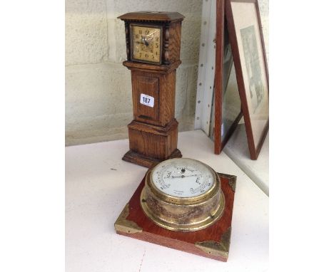 An early 20th century oak cased mantle clock modelled as a longcase clock together with a modern barometer.