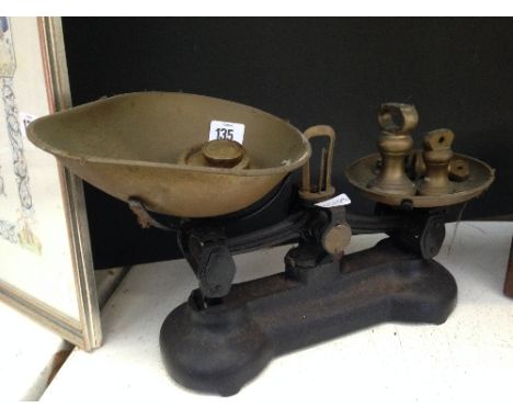 A set of kitchen scales and brass weights.