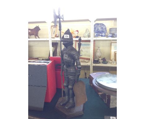 A cast iron fireside companion modelled as a Knight in Armour together with three tools.