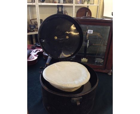 A 19th century black painted metal hat box containing two Sailor's caps from HM Cruiser with black bow and rosette ribbons to