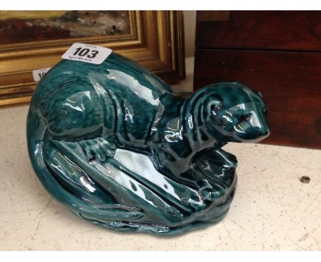 A blue glazed Poole Pottery model of an Otter.
