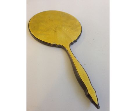 A silver and enamel dressing table hand mirror.