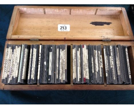 A box containing a collection of various 19th century Magic Lantern slides.