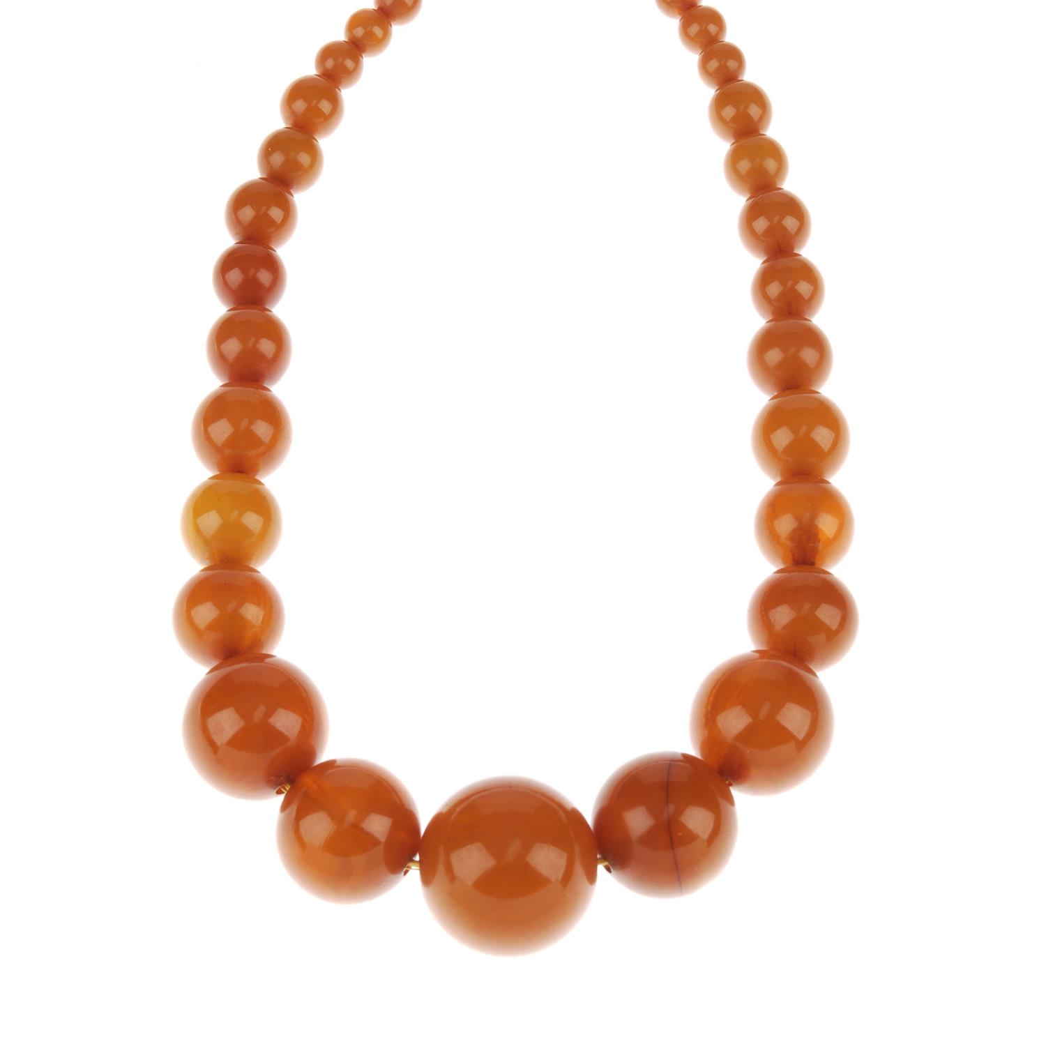 A bakelite bead necklace. Comprising thirty-one spherical bakelite ...