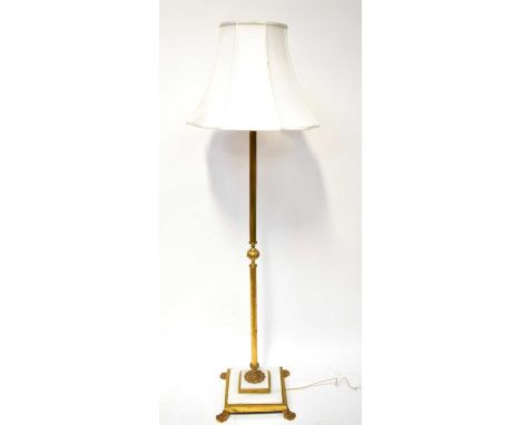 A brass-effect Corinthian column form standard lamp on an alabaster and brass square base with lion paw feet, height 143cm.Co