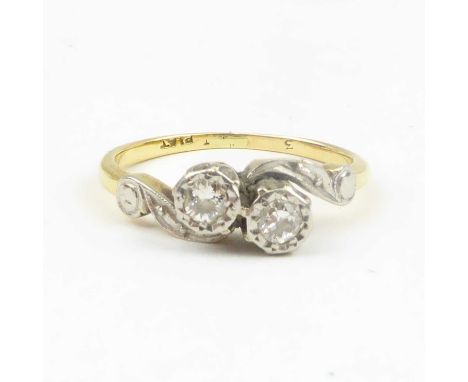 An 18ct gold ring with two bezel set brilliant cut diamonds in platinum mounts to shoulders, size L, approx. 2.7g.