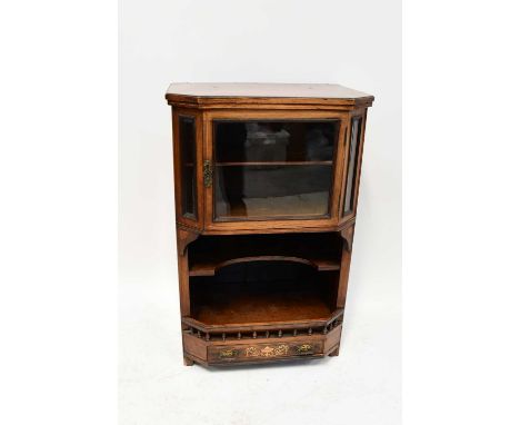 A late 19th/early 20th century walnut side cabinet with canted front, single glazed door above an open shelf and galleried un