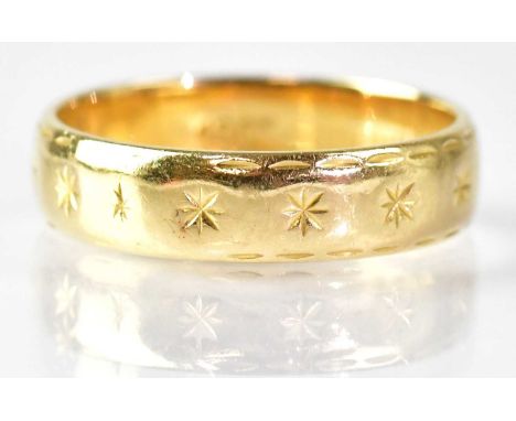 An 18ct yellow gold wedding band with engraved stars, size K, approx. 3.6g.
