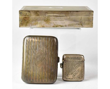 A silver cigarette box with engine turned decoration and pair of shield crests to the lid, with personal dedication engraving