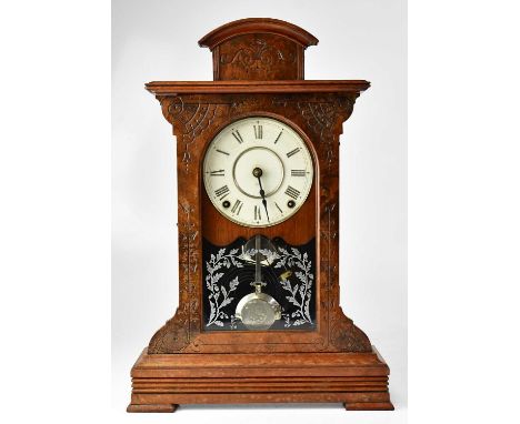 An American walnut cased mantel clock, the white enamelled dial set with Roman numerals, above acid etched glazed door decora