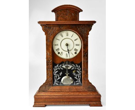 An American walnut cased mantel clock, the white enamelled dial set with Roman numerals, above acid etched glazed door decora