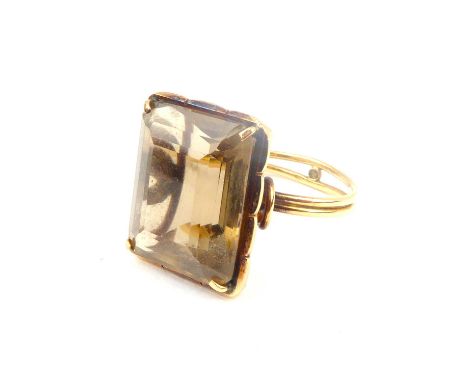 A 9ct gold dress ring with claw set square cut smoky quartz on a double-banded shank, split and joined with small gold bead, 