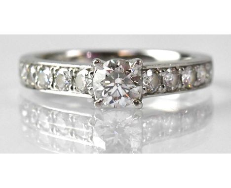 A platinum diamond solitaire ring, with five diamonds set to each shoulder, size O, approx. 5.2g, with Beaverbrooks certifica