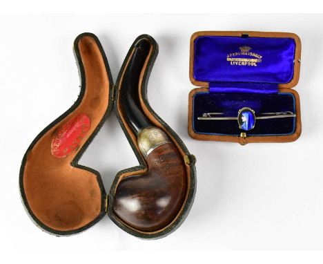 A white metal bar brooch set with an enamel oval portrait of a woman in a blue headdress, in a box retailed by J Penlington &