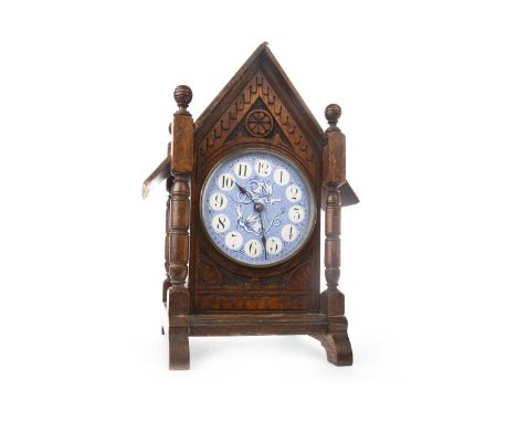 EARLY 20TH CENTURY OAK ARCHITECTURAL MANTEL CLOCK, the ceramic dial with Arabic numerals and painted in blue with two stylise