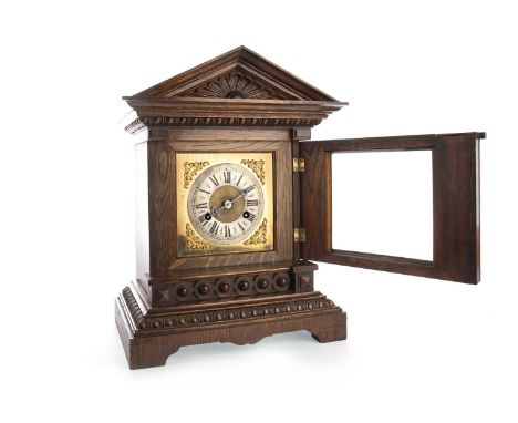 VICTORIAN OAK MANTEL CLOCK, the two train eight day movement by Junghans, the silvered dial with Roman numerals, architectura