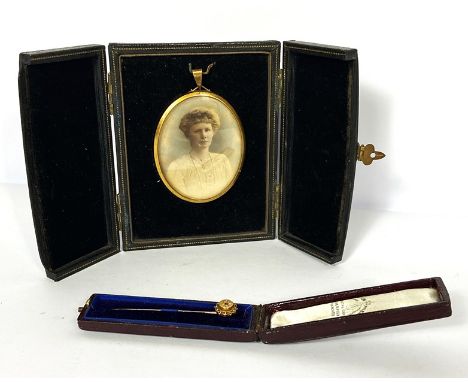 A late Victorian 15 carat gold tie pin, with inset garnet, cased, 1.5g; together with a portrait miniature of a lady, overpai