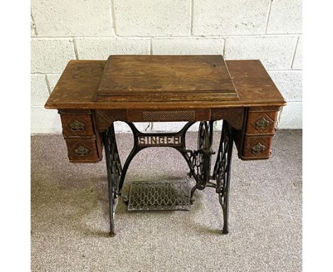 A vintage Singer sewing machine and table, with iron supports and treadle, 77cm high, 93cm wide