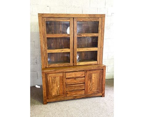 A contemporary hardwood, possibly teak, display cabinet, with two glazed cabinet doors over a base with three drawers and two