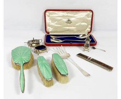 A small group of silver items, including a silver a green enamel backed three brush set; a silver bread fork, three silver co