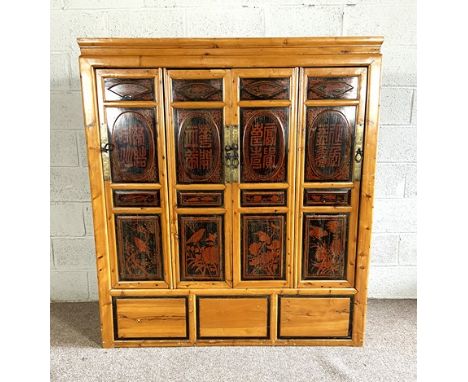 A vintage Chinese side cabinet, early/mid 20th century, with four panelled doors, each segmented with decorative lacquered pa