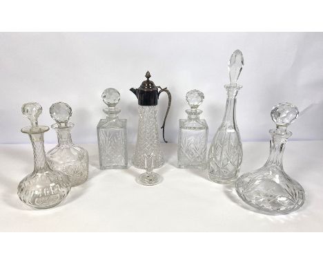 A group of decanters and a silver plated and moulded glass claret jug, including a pair of square based spirit decanters, a p