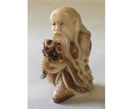 JAPANESE BONE NETSUKE - of an old man carrying flowers dressed in robes. Meiji period. Carved and engraved to a very high sta
