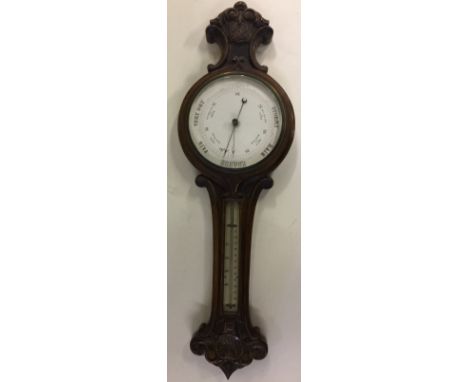 OAK CASED CARVED BAROMETER - with thermometer above. Measures 82cm tall