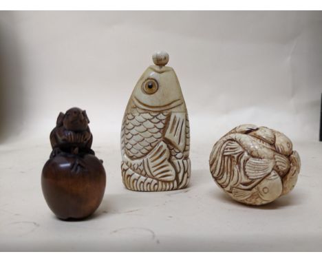 Japanese carved wood netsuke of a rat sitting on an apple, a bone snuff bottle in the form of a fish head with glass eyes, an