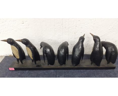 A vintage style painted metal display of seven penguins in different poses, Location: 