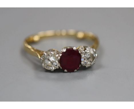 An 18ct and plat, ruby and diamond set three stone ring, size M/N, gross 3 grams.