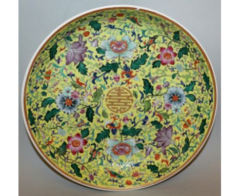 A GOOD QUALITY CHINESE FAMILLE ROSE YELLOW-GROUND PORCELAIN DISH, decorated with scroll and leaf stemmed flowerheads enclosin