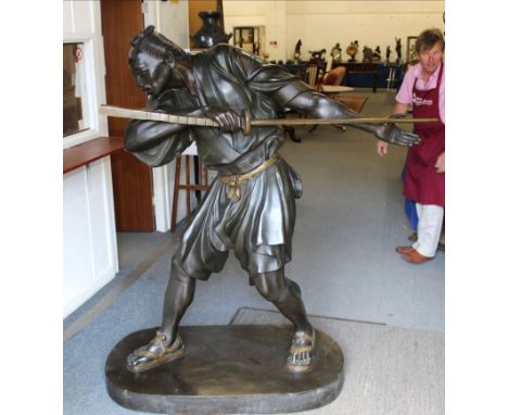 A MASSIVE PAIR OF SIGNED 20TH CENTURY JAPANESE PATINATED BRONZE MODELS OF BATTLING SAMURAI, each standing with drawn swords i