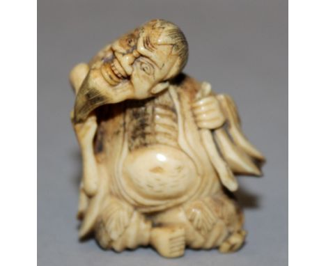AN 18TH/19TH CENTURY JAPANESE CARVED STAGHORN NETSUKE OF GAMMA SENNIN, seated with his head at a sharp angle, his toad on his