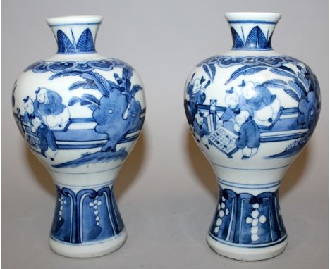 A PAIR OF CHINESE BLUE & WHITE PORCELAIN VASES, each decorated with a continuous scene of boys playing in a fenced garden set