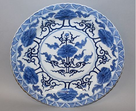 A 19TH CENTURY CHINESE BLUE & WHITE PORCELAIN DISH, painted in a retrospective style with stylised heads of peony, the base w