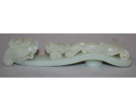 A CHINESE PALE CELADON JADE-LIKE BELT HOOK, of traditional form, 4.75in long.