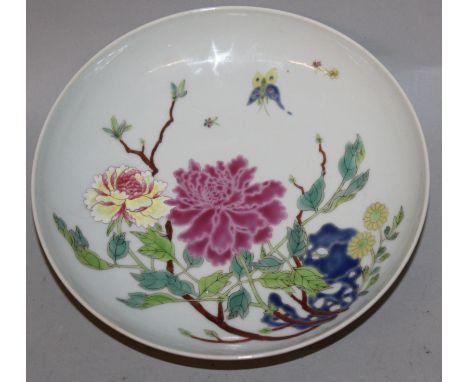 A CHINESE FAMILLE ROSE PORCELAIN SAUCER DISH, decorated with butterflies hovering above peony, flowers, leafage and rockwork,