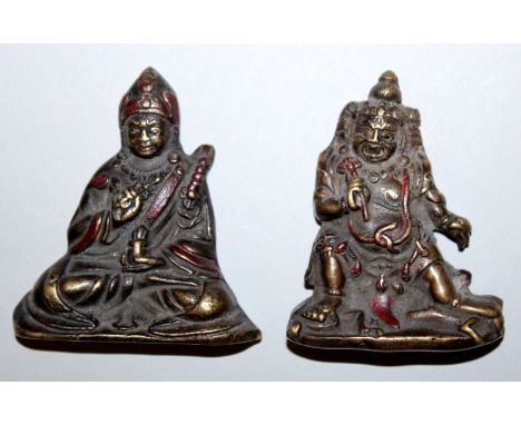 TWO SMALL SINO-TIBETAN BRONZE FIGURES OF IMMORTALS, each with some red lacquered decoration, one with an inscription to its r
