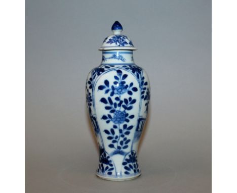 A CHINESE KANGXI PERIOD BLUE & WHITE PORCELAIN VASE & COVER, circa 1700, the sides of the baluster form body painted with pan