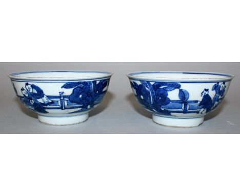 A PAIR OF CHINESE BLUE & WHITE PORCELAIN BOWLS, each decorated with scenes of boys playing in fenced garden settings, each ba