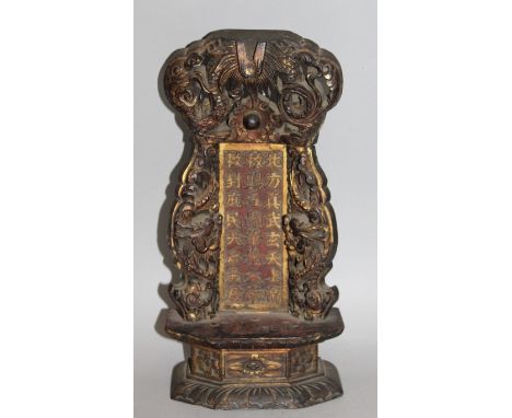 A CHINESE GILDED & LACQUERED CARVED WOOD SHRINE, with a pierced dragon surround enclosing a panel of calligraphy on a chamfer