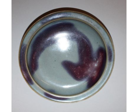 A JUN-TYPE PURPLE SPLASHED CERAMIC DISH, with an everted rim, 6.75in diameter.
