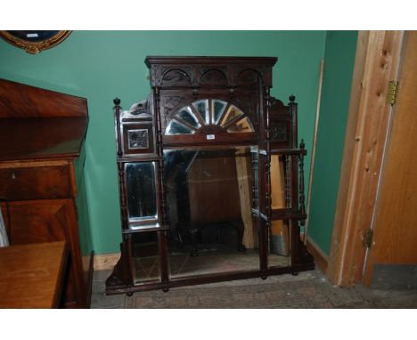 A BP over mantle with turned columns and carved detail with sunray feature to the upper part supported by bun feet