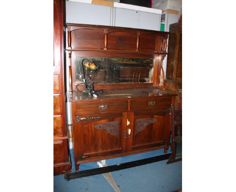 An art nouveau Walnut mirror back Sideboard, having moulded top with upper shelf and well turned supports, over rectangular b