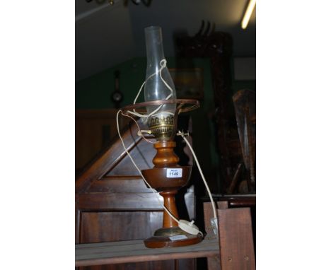 An electric lamp with clear glass chimney in the style of an oil lamp