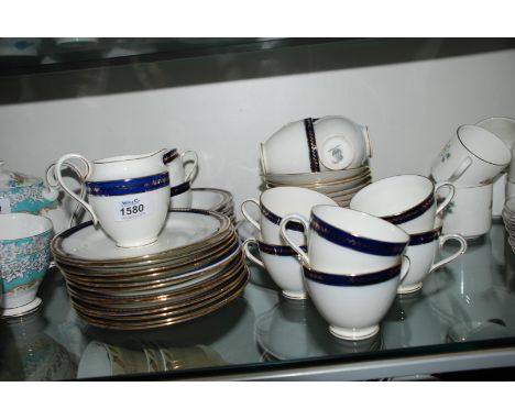 A Crown Chelsea part Teaset in navy and white and comprising twelve Cups, eleven Saucers, twelve Tea Plates, Milk Jug, Cake P