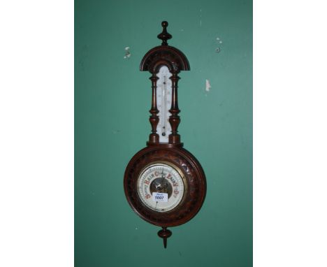 A wooden Barometer with carved design and a turned finial 