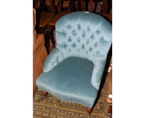 A low Victorian upholstered Nursing Chair, having arch top button upholstered back and arms with serpentine fronted seat and 